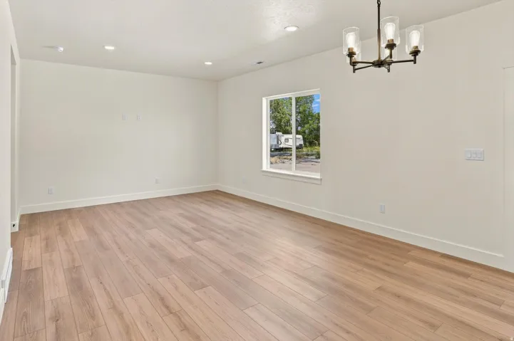 Expansive room featuring wood-finish flooring, recessed lighting, and a multi-pane window