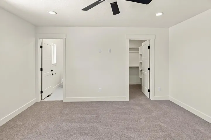Plush carpet flooring, recessed lighting, ceiling fan, and built-in closet shelving