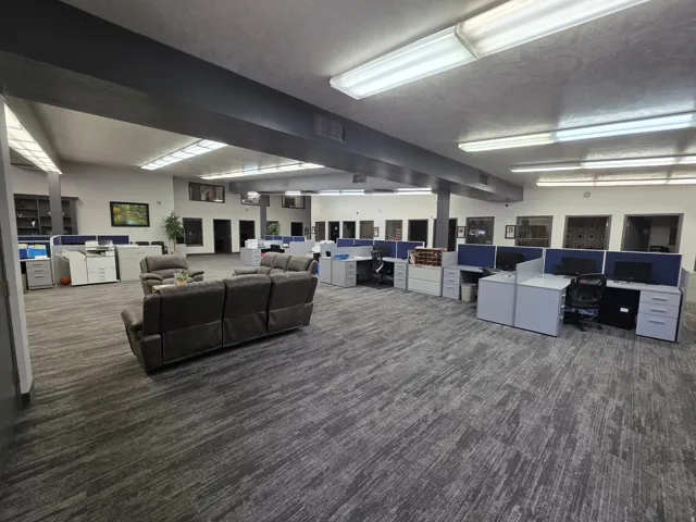 Open-concept office space with patterned carpet flooring, recessed lighting, and integrated cubicle workstations