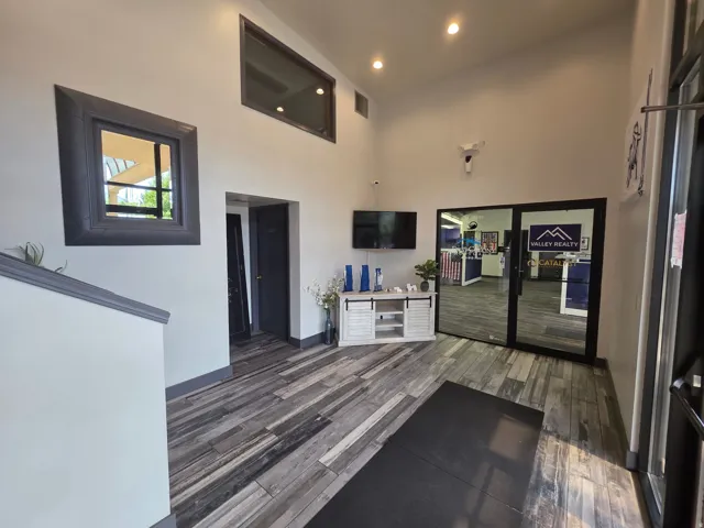 Vaulted ceiling, recessed lighting, wood-finish flooring, interior transom window, and glass panel entry doors