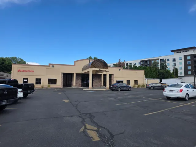 Commercial building with a tan stucco exterior, stone-clad entryway, and a covered portico