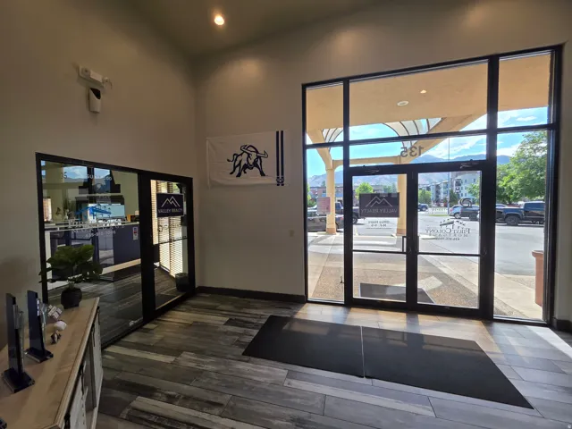 Wood-finish flooring with a glass-paneled entry door and expansive window wall