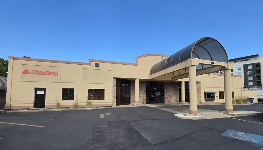 Commercial building featuring a covered entryway, multiple display windows, and stone veneer accents