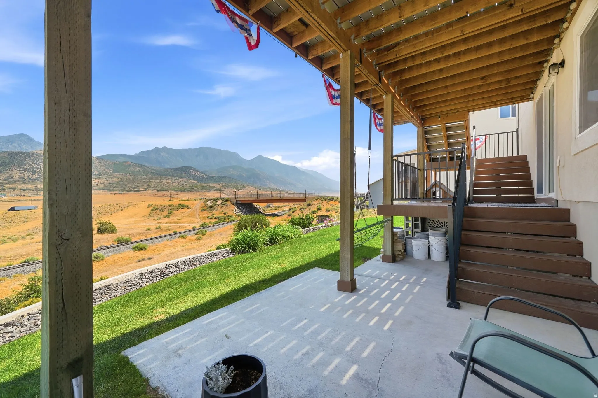 Concrete patio with a wood-finish overhead deck structure and supporting columns