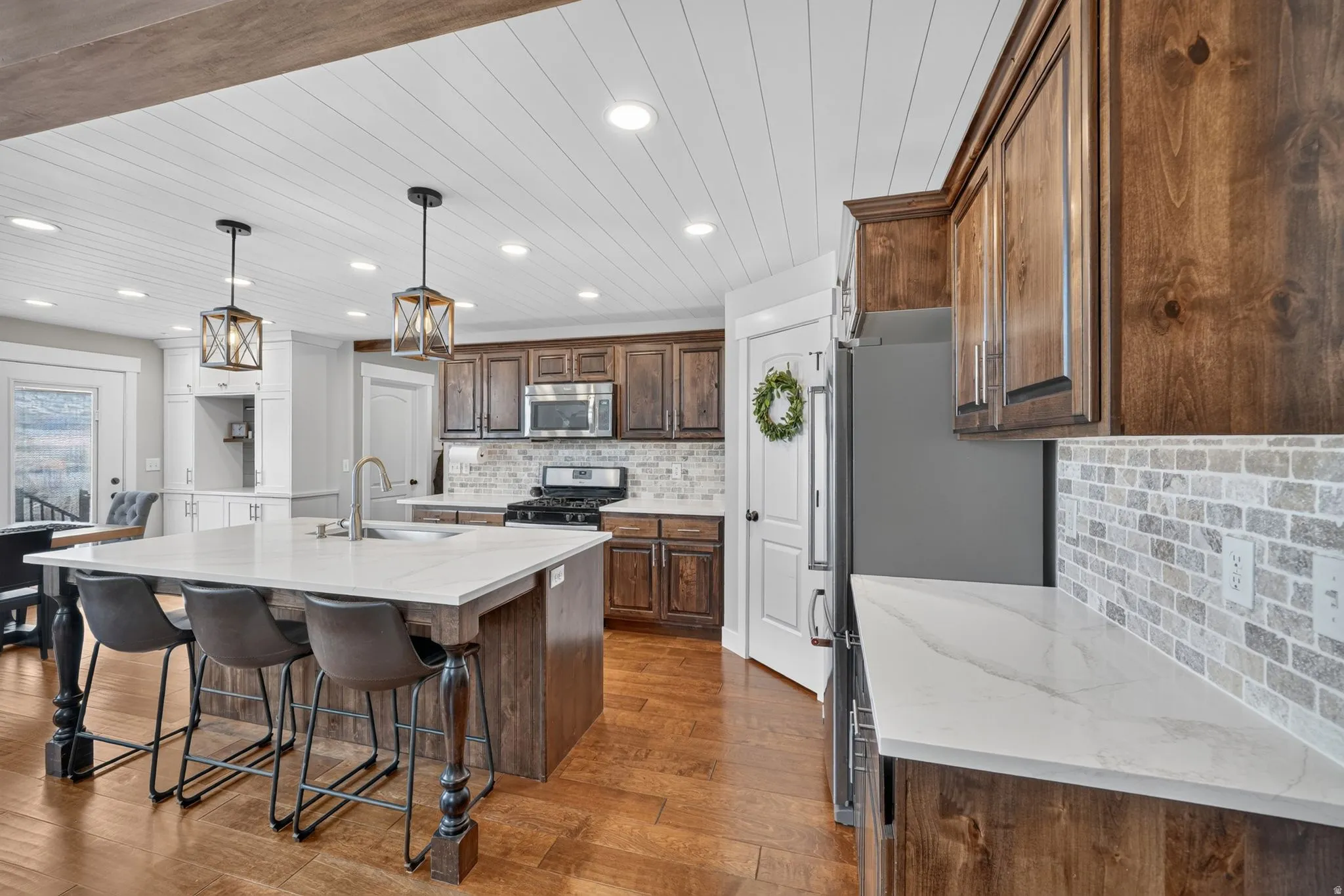Kitchen featuring wood-finish flooring, white shiplap ceiling, recessed lighting, and a large island with white countertops