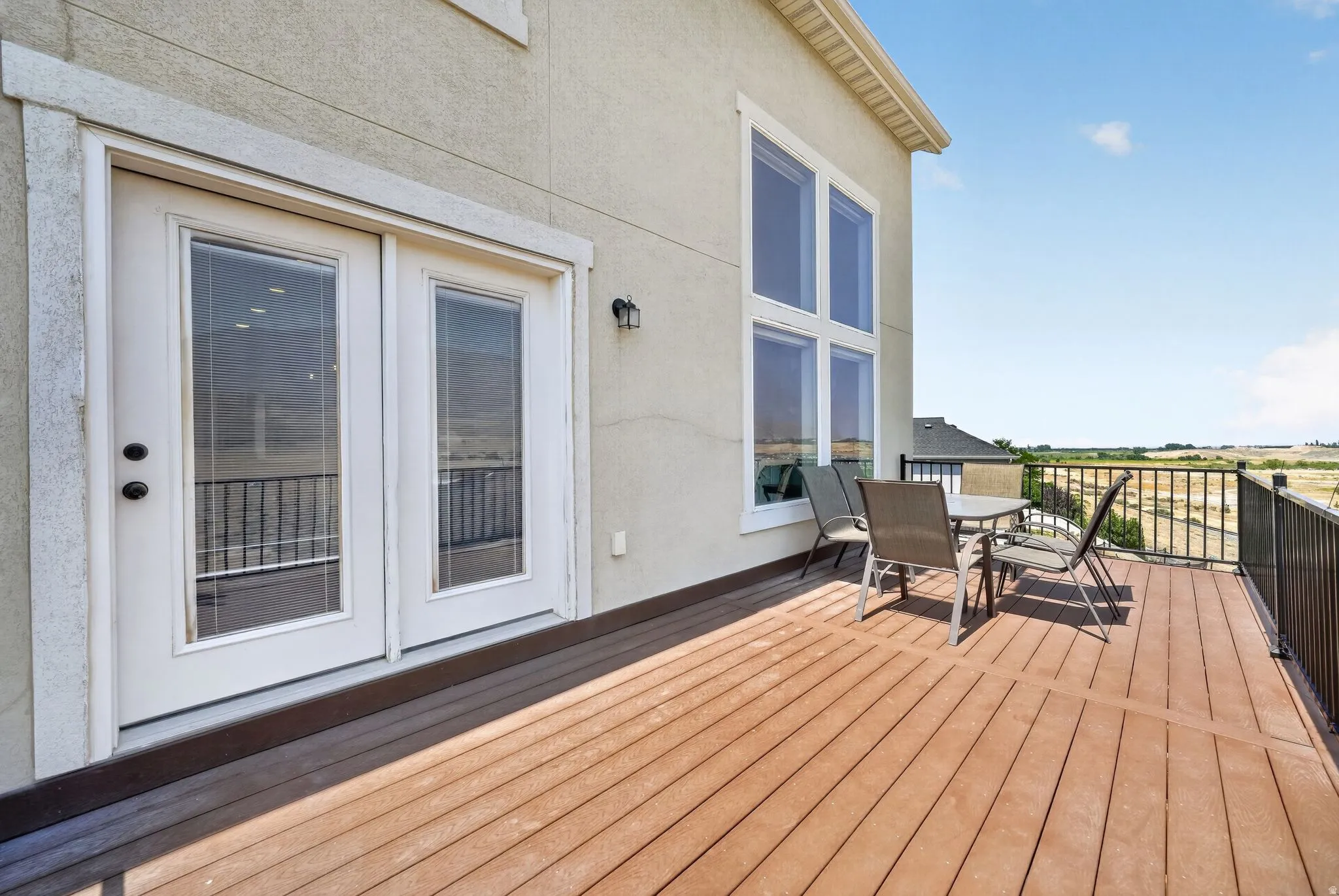 Expansive outdoor deck with wood-finish flooring and black metal railing
