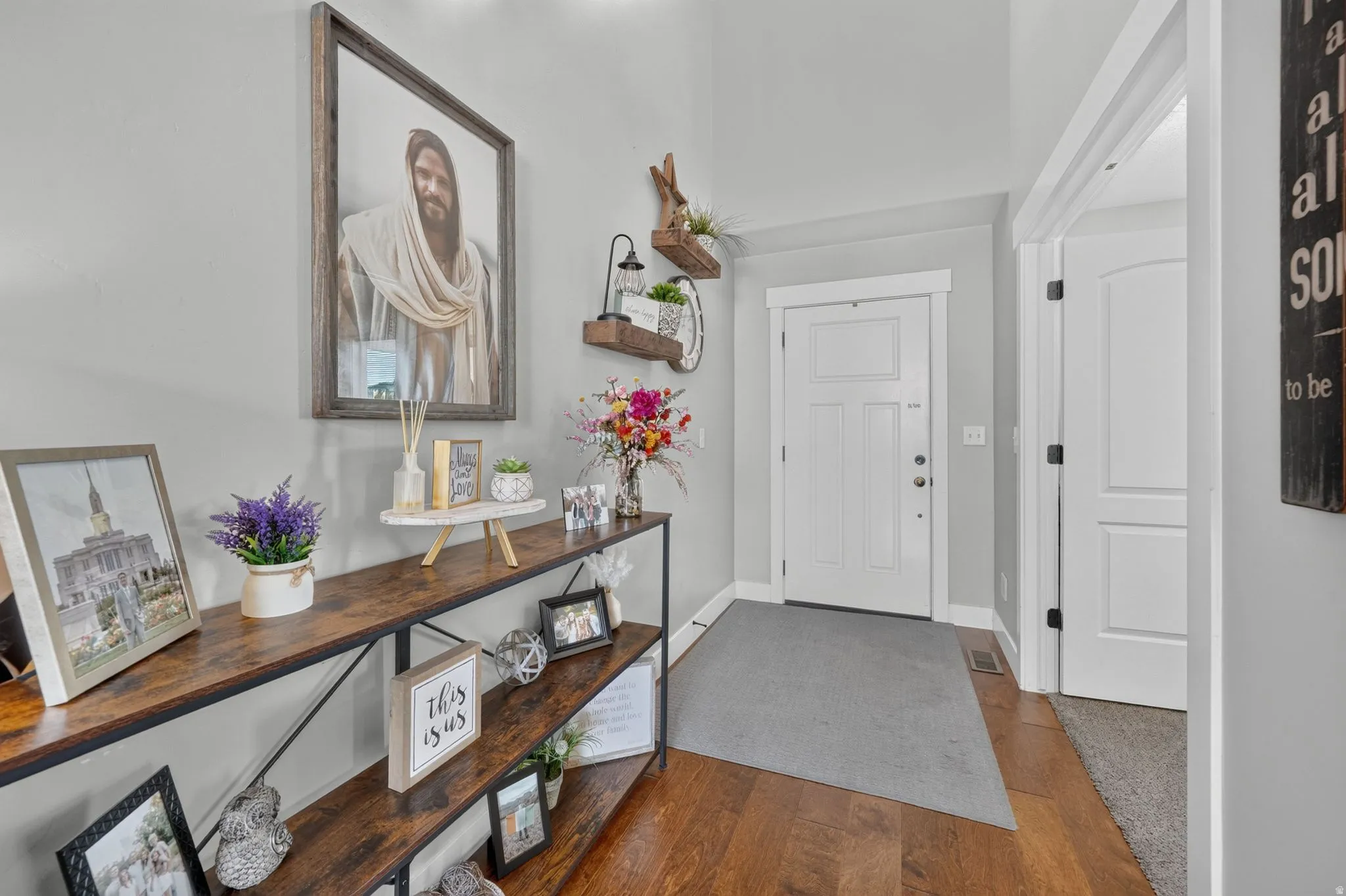 Hardwood flooring, light gray wall paint, white trim, and a white paneled door