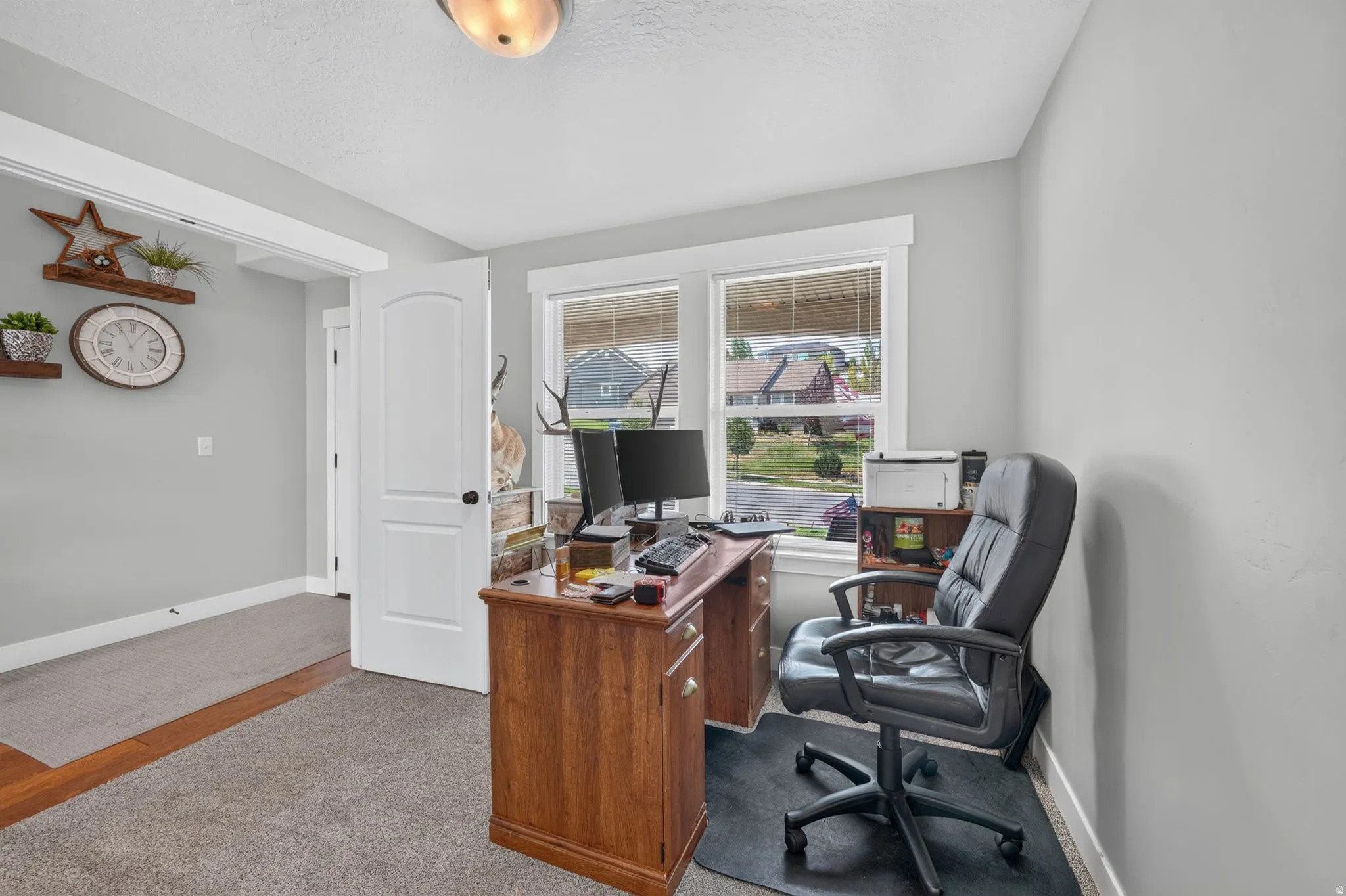 Carpeted flooring with a wood-finish inlay, white trim, recessed lighting, and a white interior door