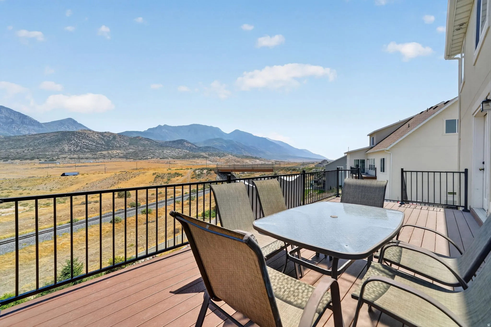 Spacious exterior deck with composite flooring and black metal railing