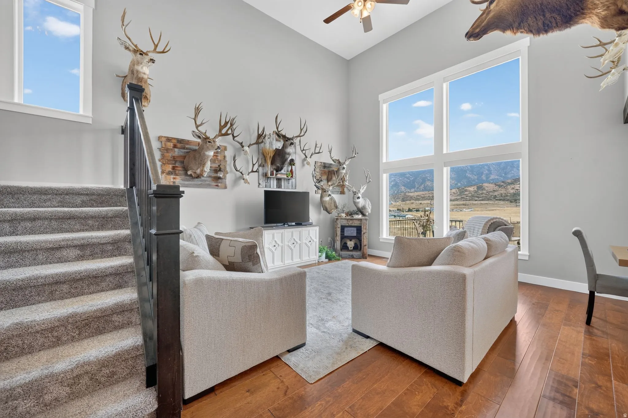 Two-story windows with mountain scenery, vaulted ceilings, and wood-finish flooring
