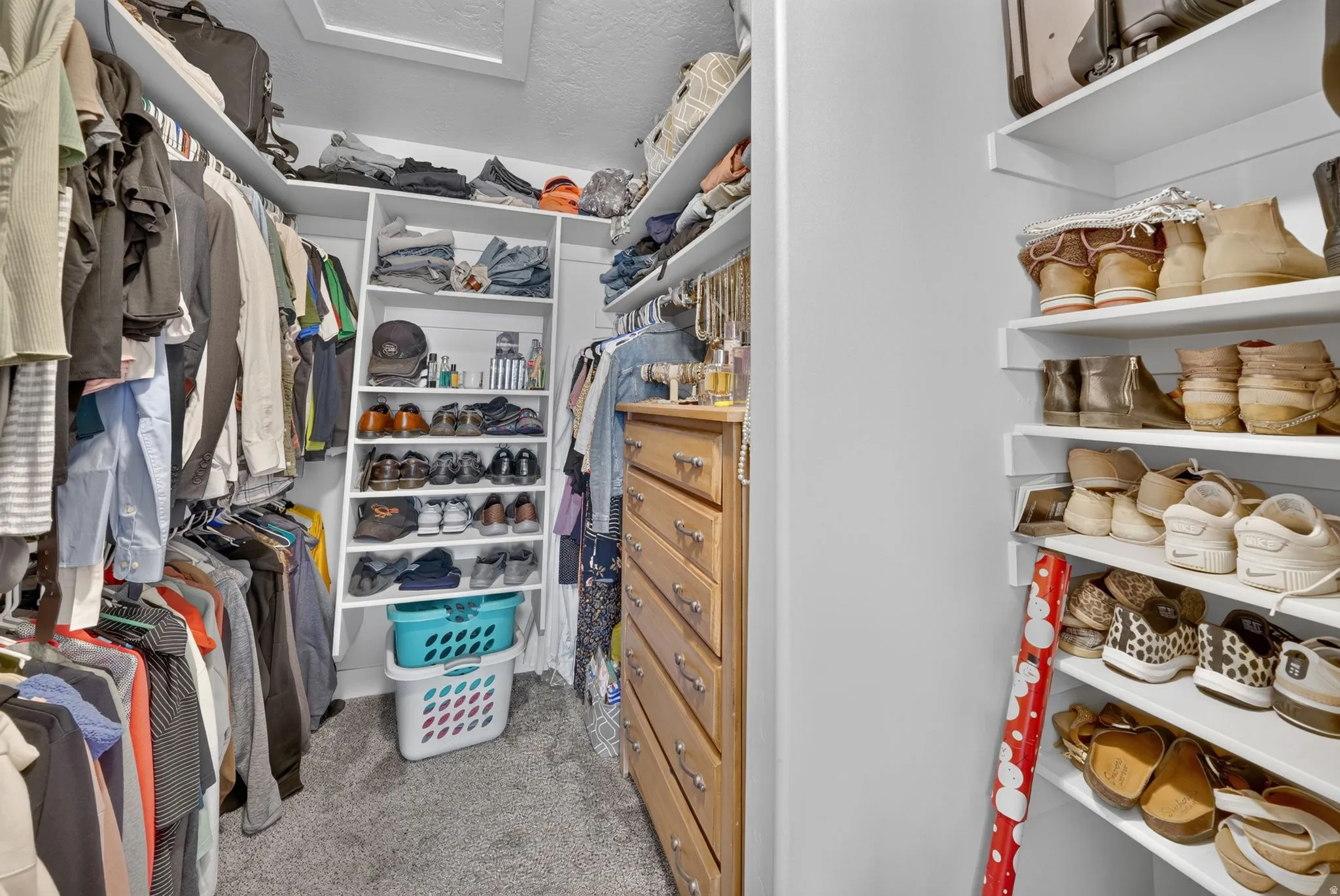 Recessed lighting, built-in shelving, wood-finish dresser with metal hardware, carpet flooring, and white walls