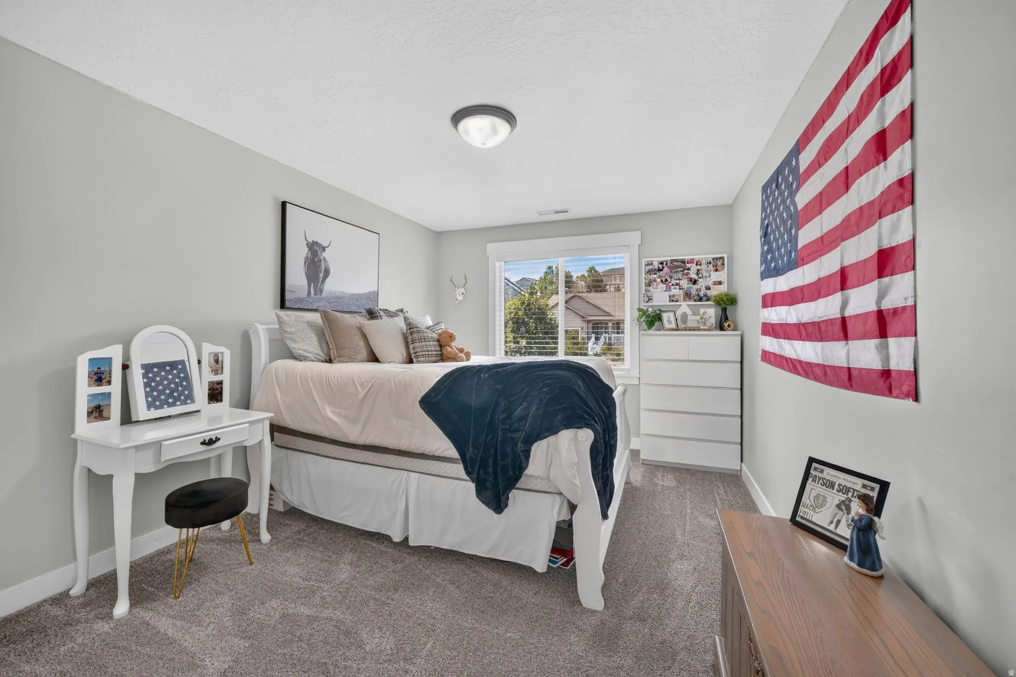 Light gray wall paint, recessed window with horizontal blinds, flush mount ceiling light fixture, and gray carpeting