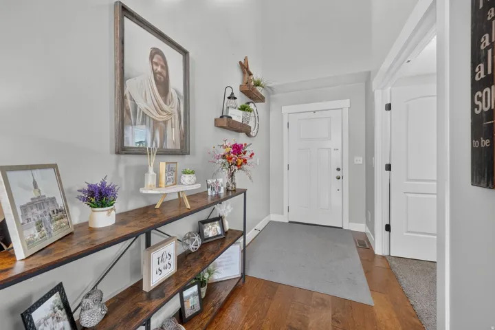 Hardwood flooring, light gray wall paint, white trim, and a white paneled door