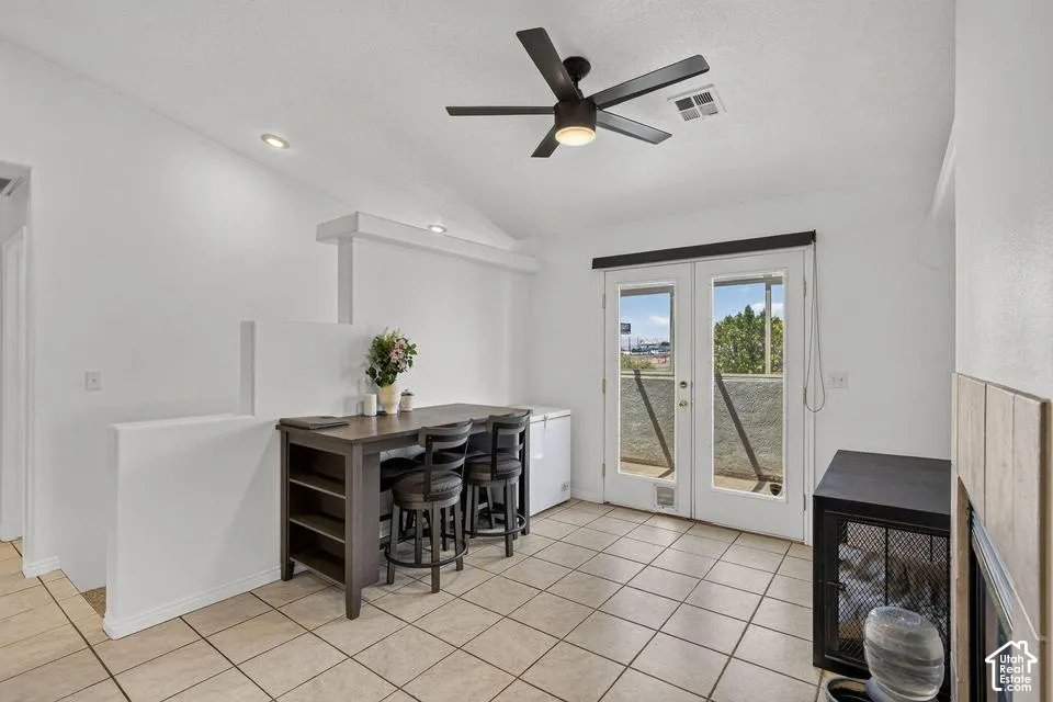 Vaulted ceiling with a ceiling fan, recessed lighting, tile flooring, and double French doors