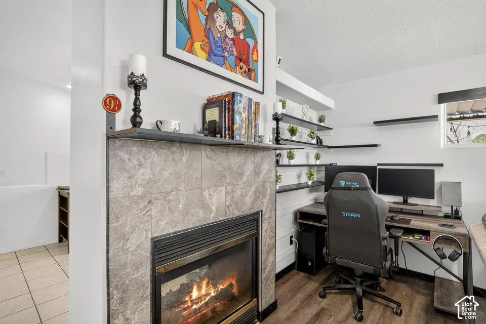 Fireplace with stone tile surround, wood mantel, and built-in shelving