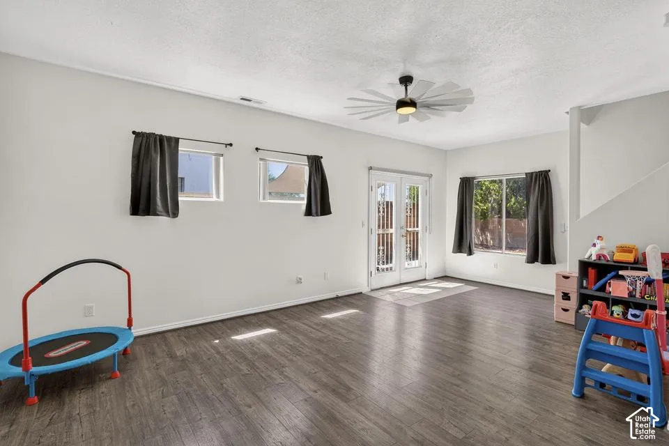Wood-finish flooring, white walls, and a contemporary ceiling fan