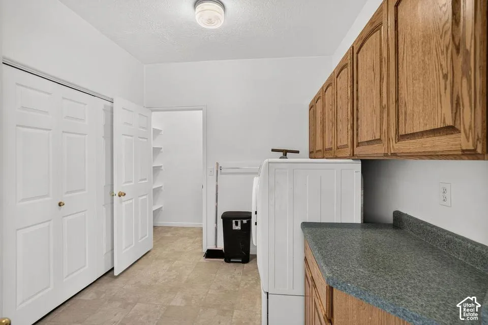 Wood-finish cabinetry with a laminate countertop, featuring a built-in closet with bi-fold doors, recessed shelving, and a ceiling-mounted light fixture