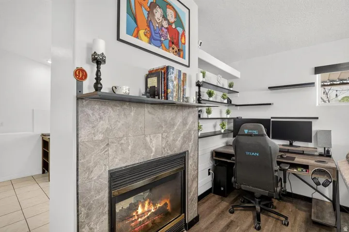 Fireplace with stone tile surround, wood mantel, and built-in shelving