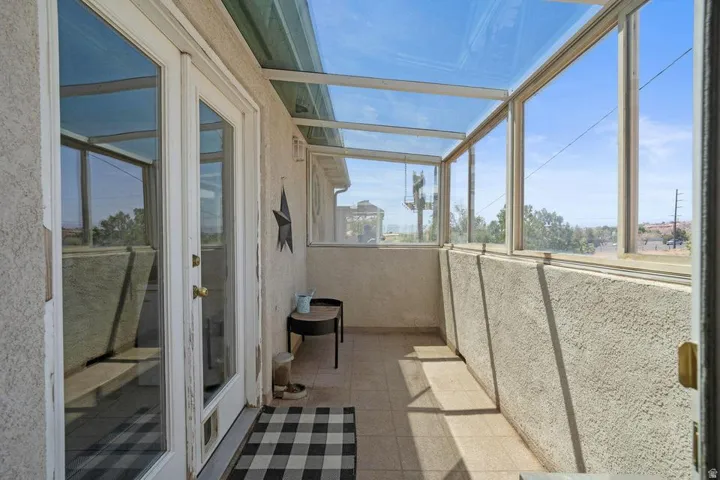 Enclosed patio with full-light French doors, glass roof, and tiled flooring