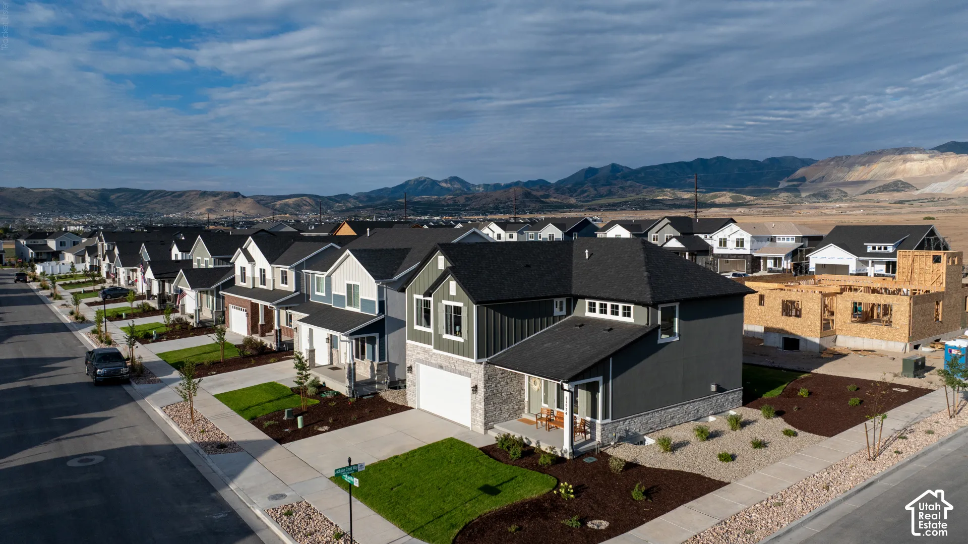 Modern residential street with newly constructed homes featuring varied exterior finishes and attached garages
