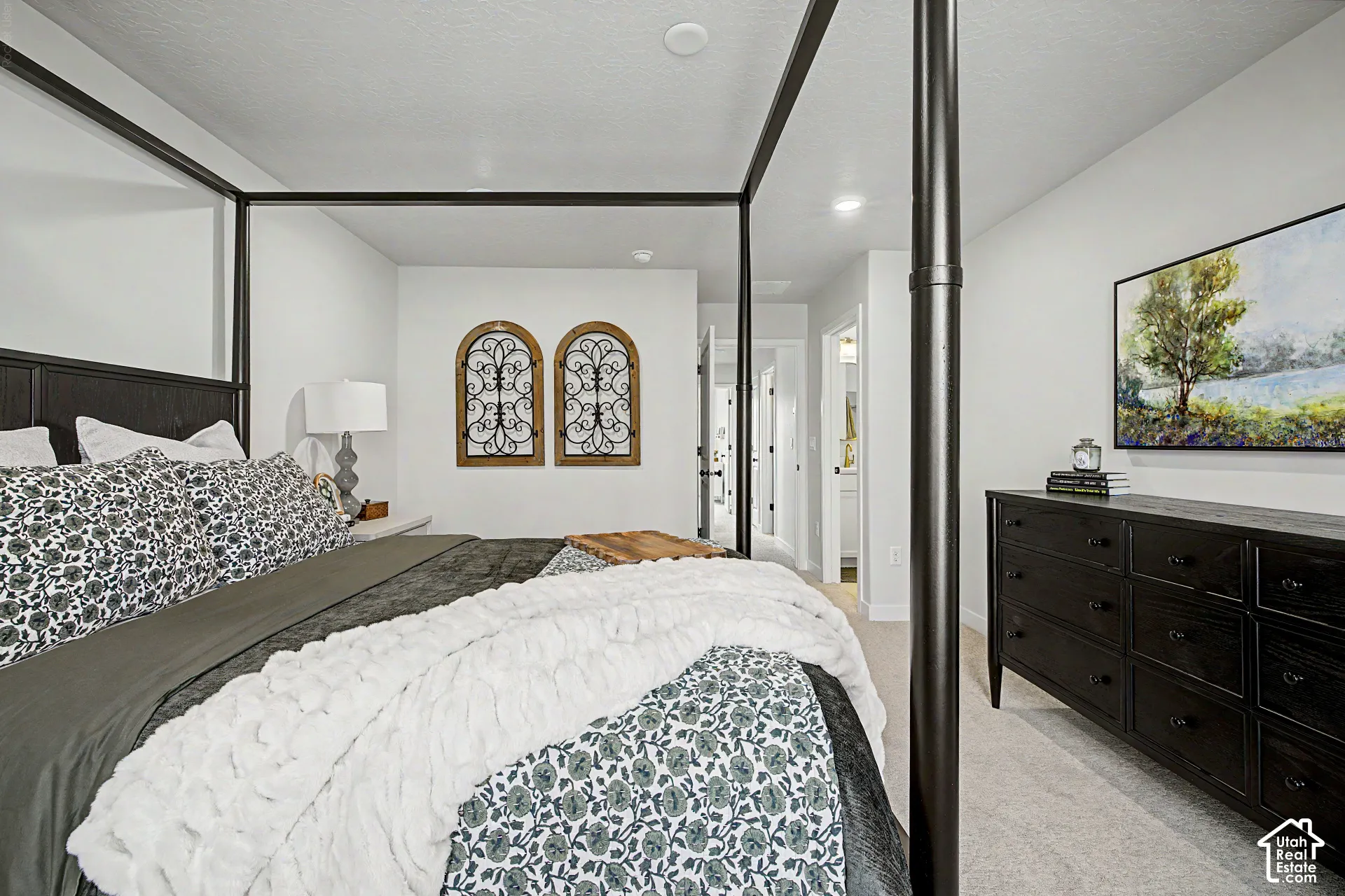 Recessed lighting, light-toned carpeting, and a dark wood-finish headboard