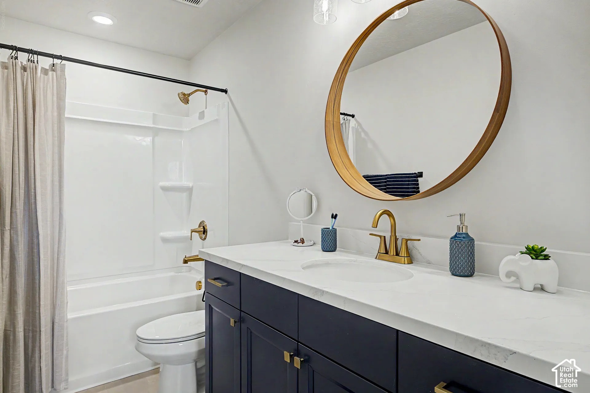 White solid-surface bathtub and shower combination with brass-finish fixtures