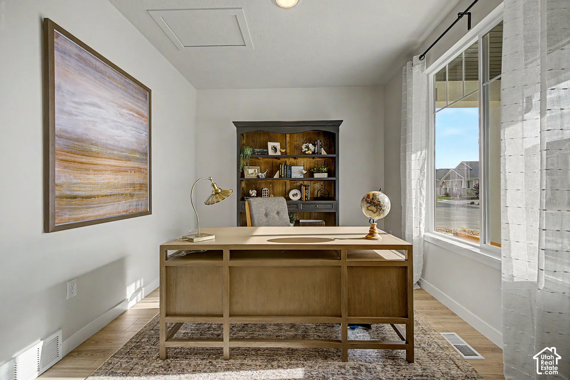 Bright interior space featuring a large window, light-toned wood-finish flooring, and light wall finishes