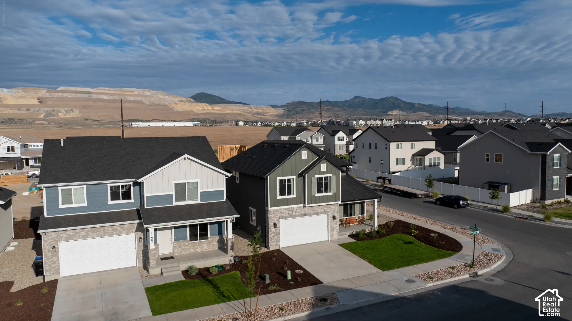 Modern two-story residence with a two-car garage, stone and siding exterior, and a landscaped front yard