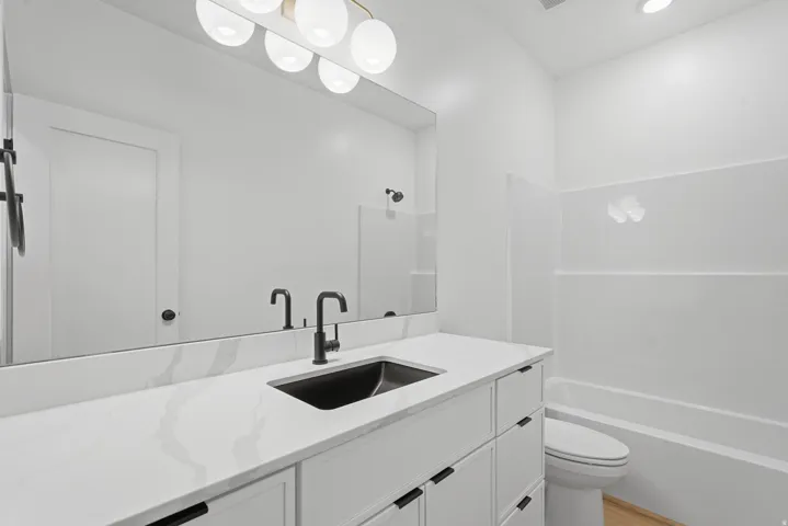White vanity with extensive countertop space, undermount sink, and matte black faucet