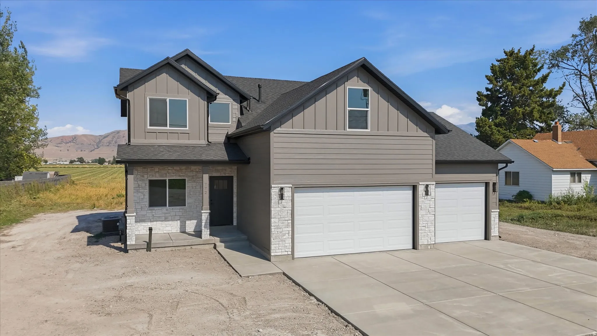 Contemporary exterior featuring horizontal siding, vertical board and batten accents, and stone veneer detailing