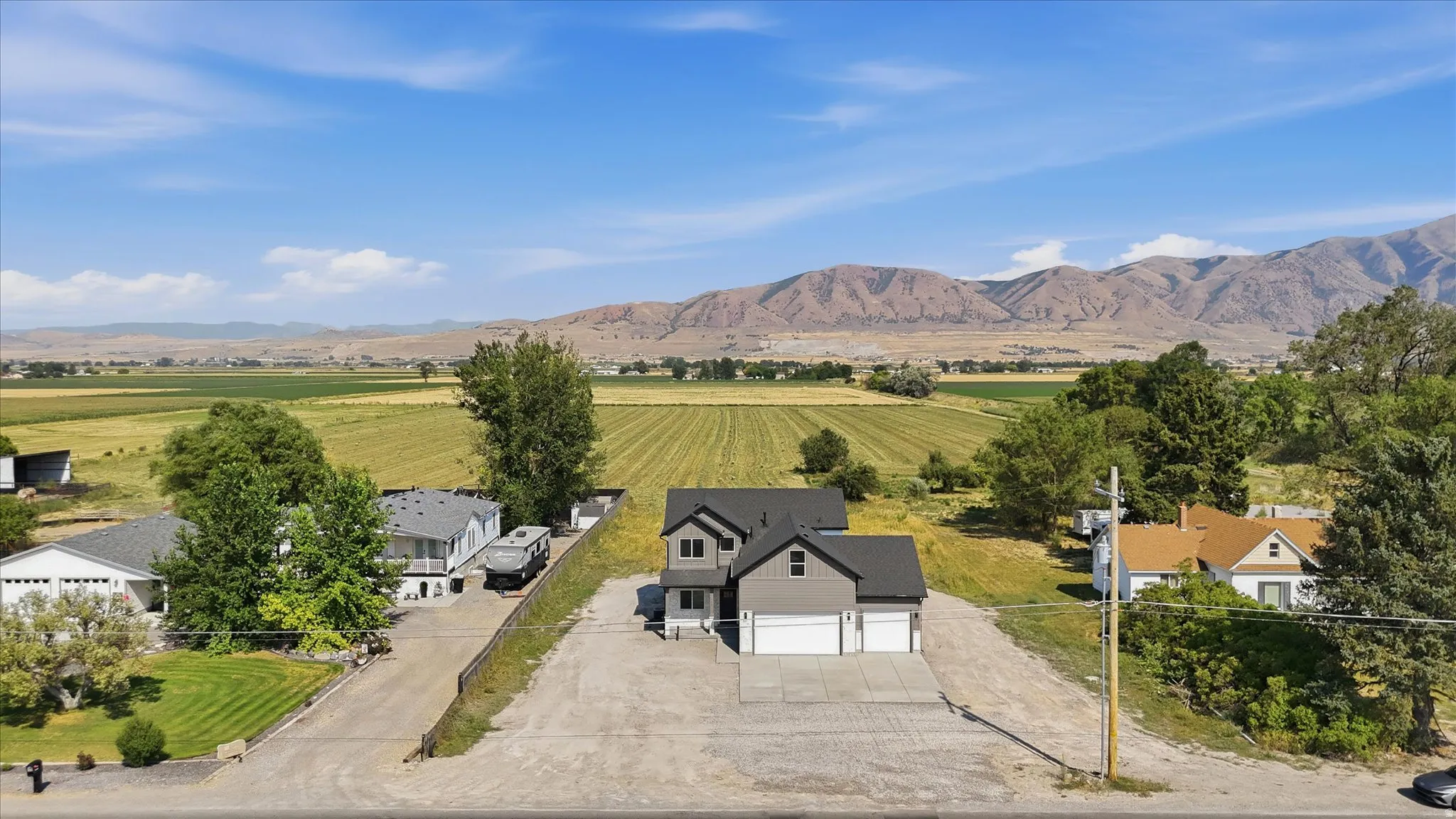 Modern exterior with a two-car garage, concrete driveway, and gravel lot