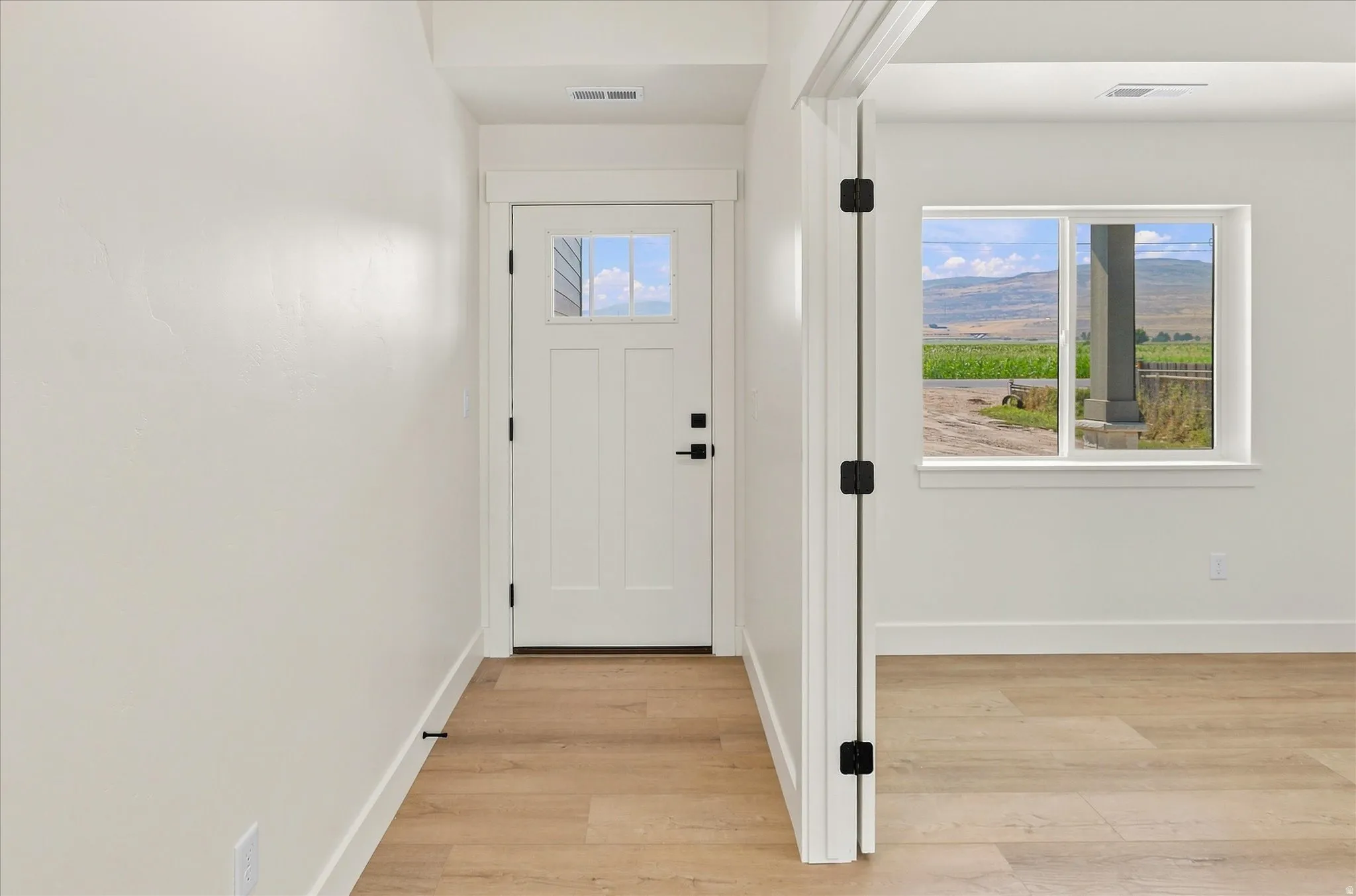 Light wood-finish flooring with white baseboards