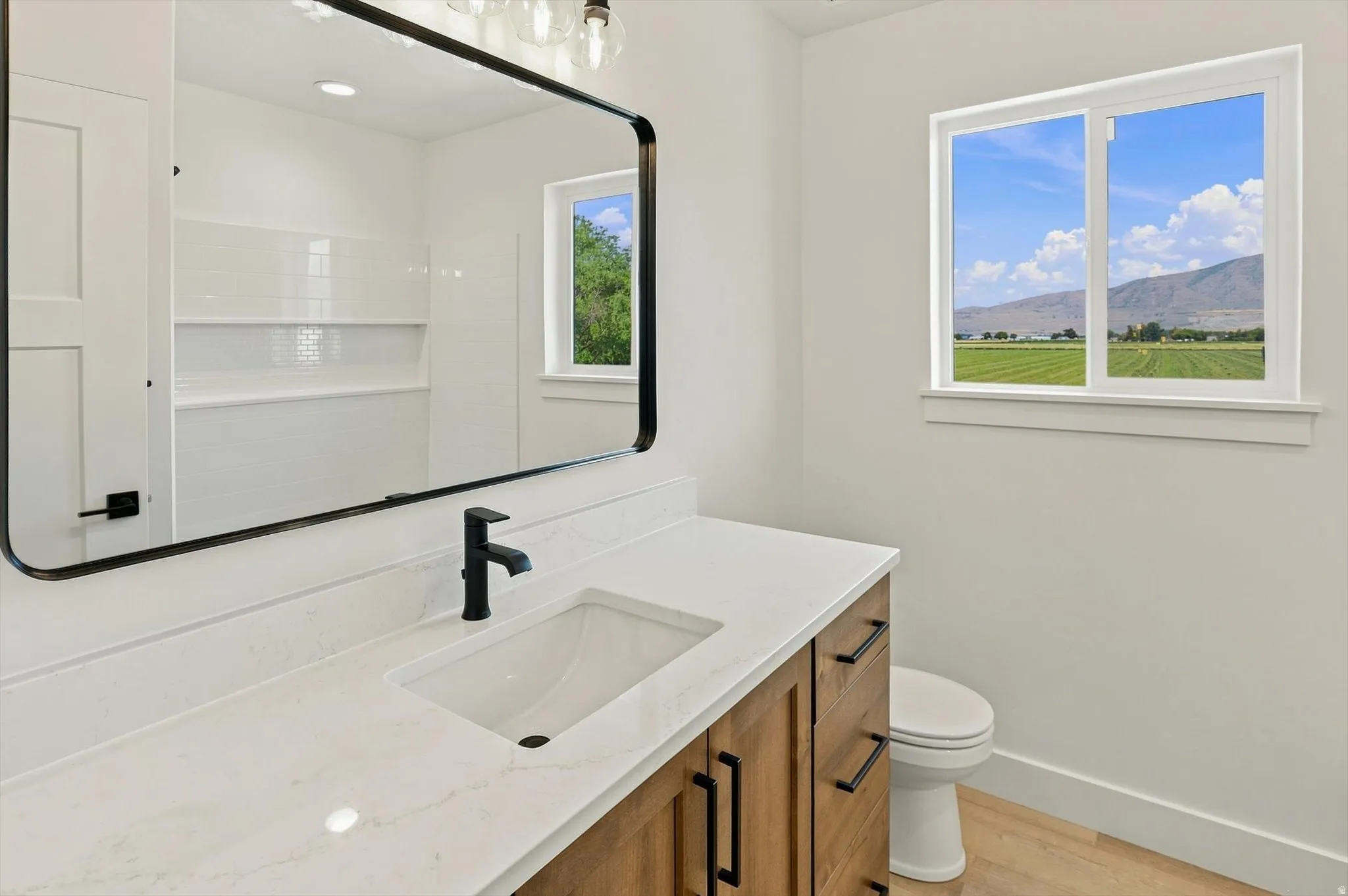 Floating vanity with wood-finish cabinetry, integrated sink, and white countertop