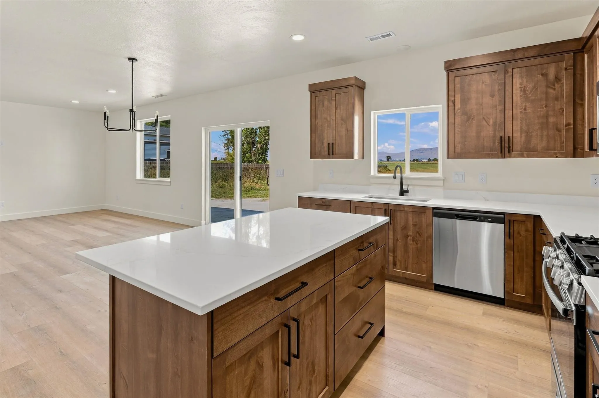 Kitchen with wood-finish flooring, white countertops, and dark wood cabinetry