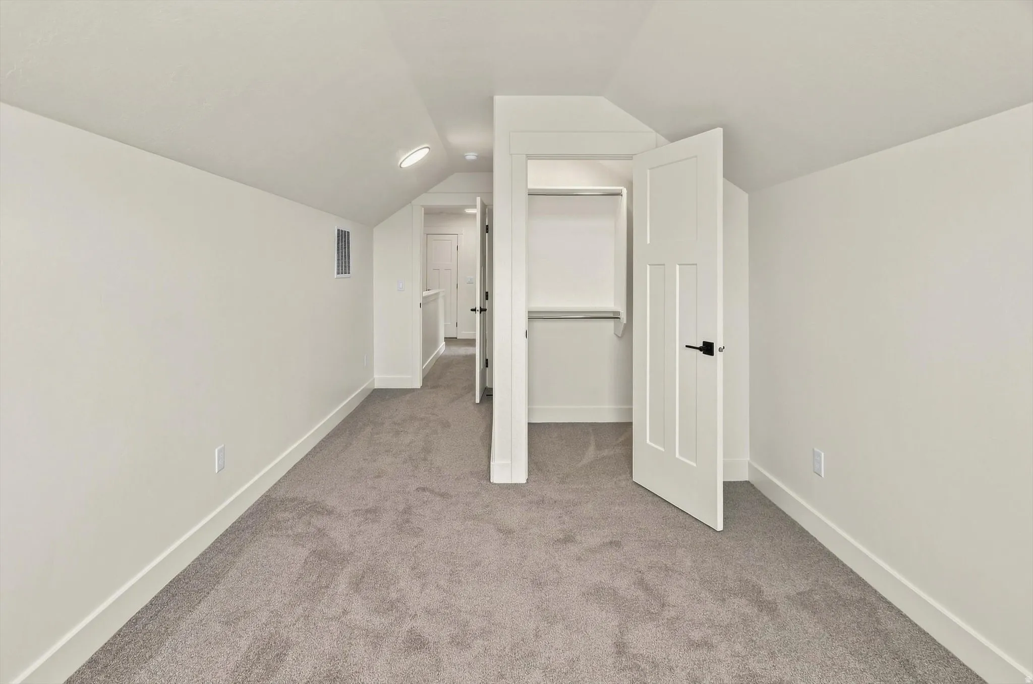 Neutral wall paint, gray carpeting, recessed ceiling lighting, white interior doors, built-in closet shelving
