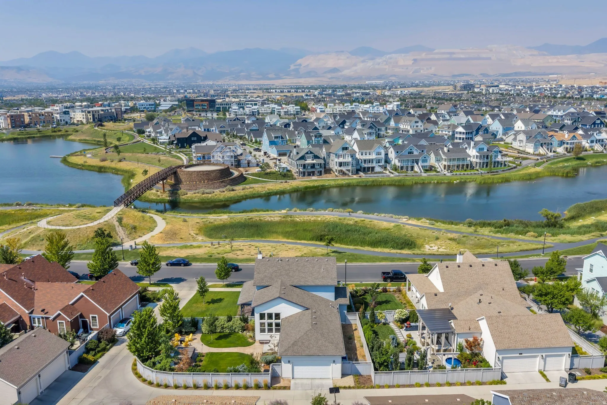 Aerial perspective showcasing residential properties within a community featuring a prominent lake and surrounding green spaces