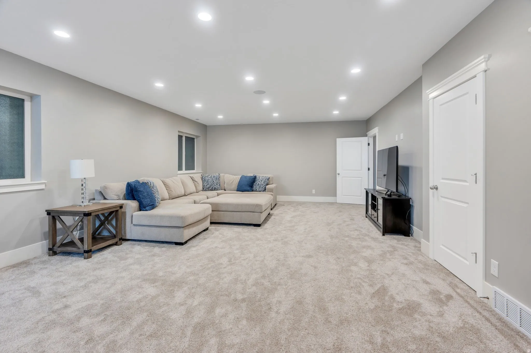 Recessed lighting throughout, light gray wall paint, and white trim