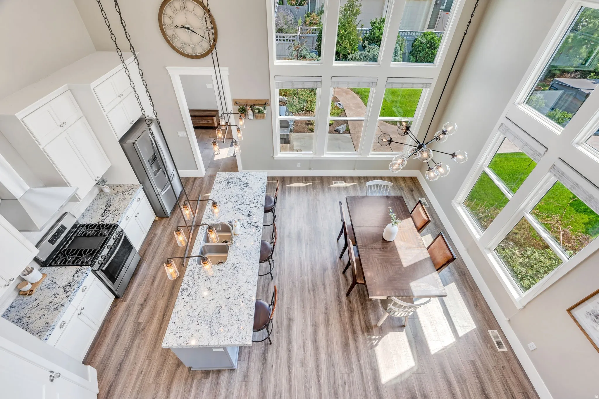 Open-concept kitchen and dining area featuring a vaulted ceiling and an expansive window wall