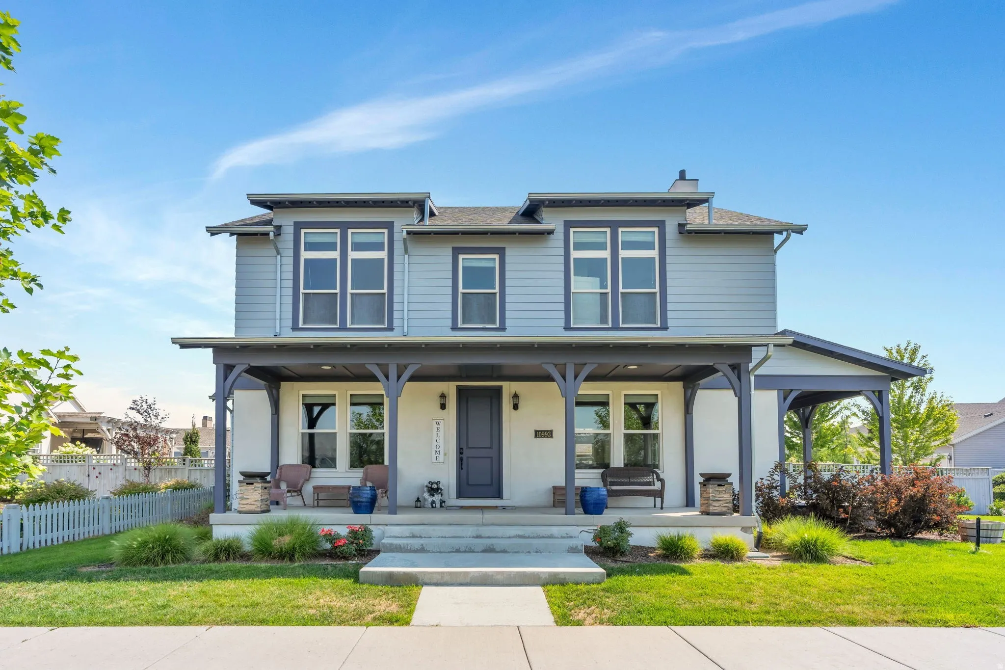 Two-story residence with a covered front porch featuring decorative columns