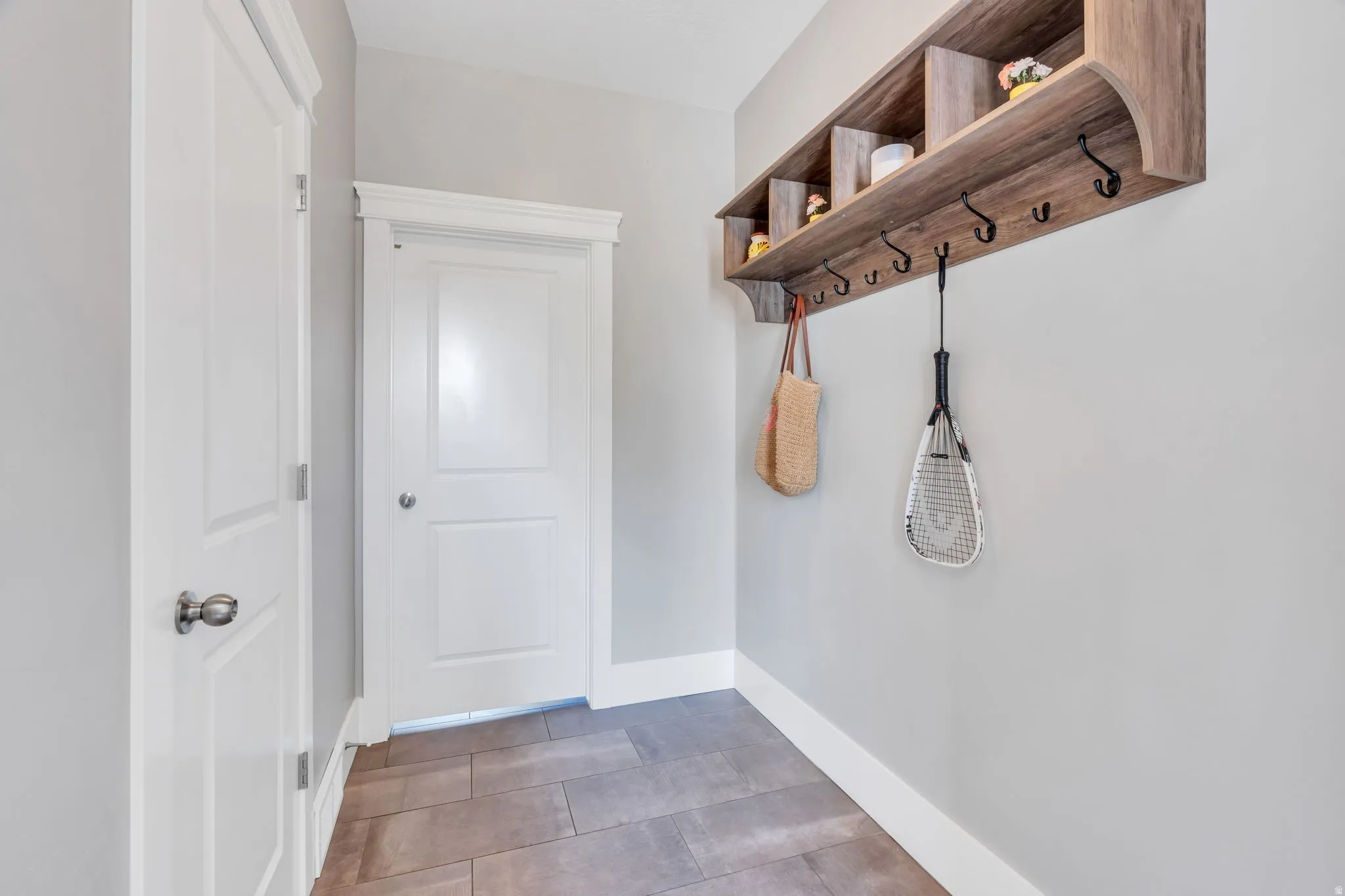 Built-in wood-finish shelving with integrated storage cubbies and coat hooks