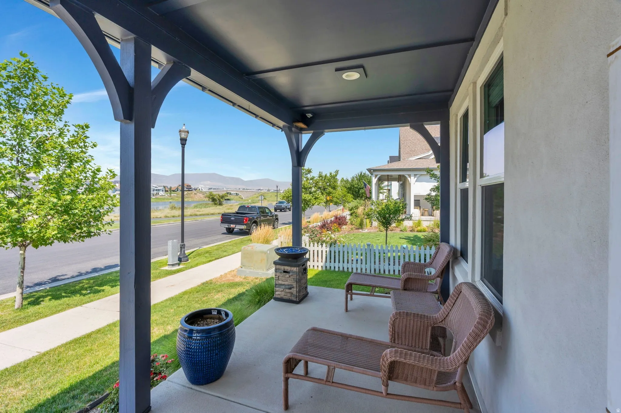 Covered concrete patio featuring sturdy support beams and recessed lighting