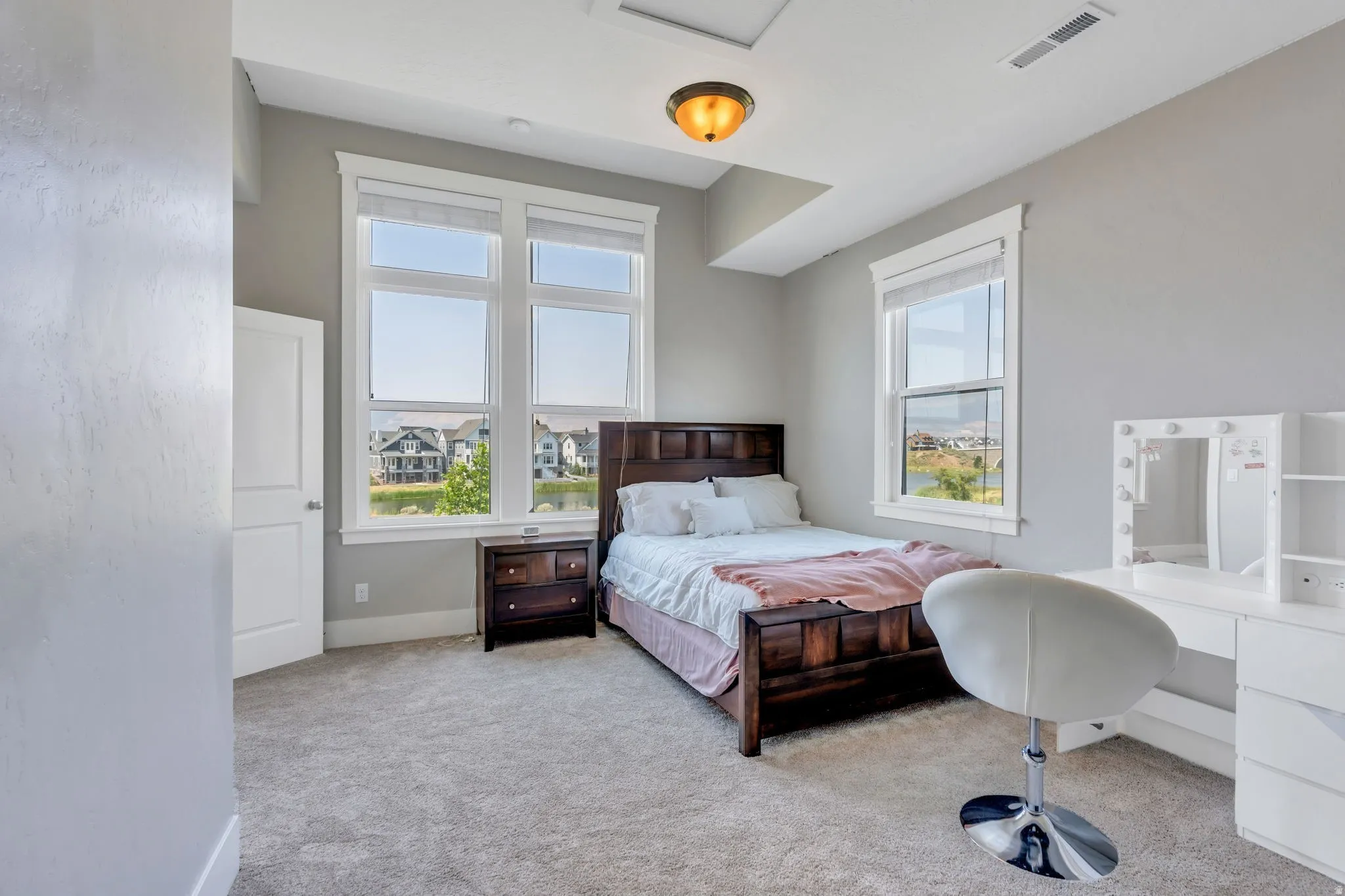 Plush carpet flooring, multiple windows, semi-flush mount ceiling light, painted walls, white trim