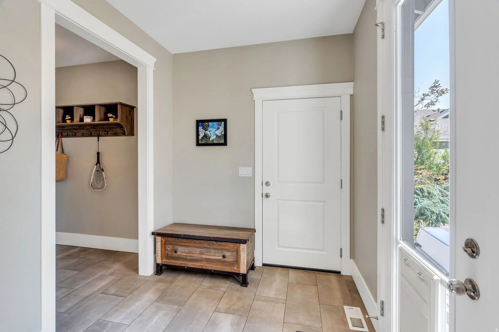 Entryway featuring a white paneled door, light-colored wall paint, and wood-finish flooring