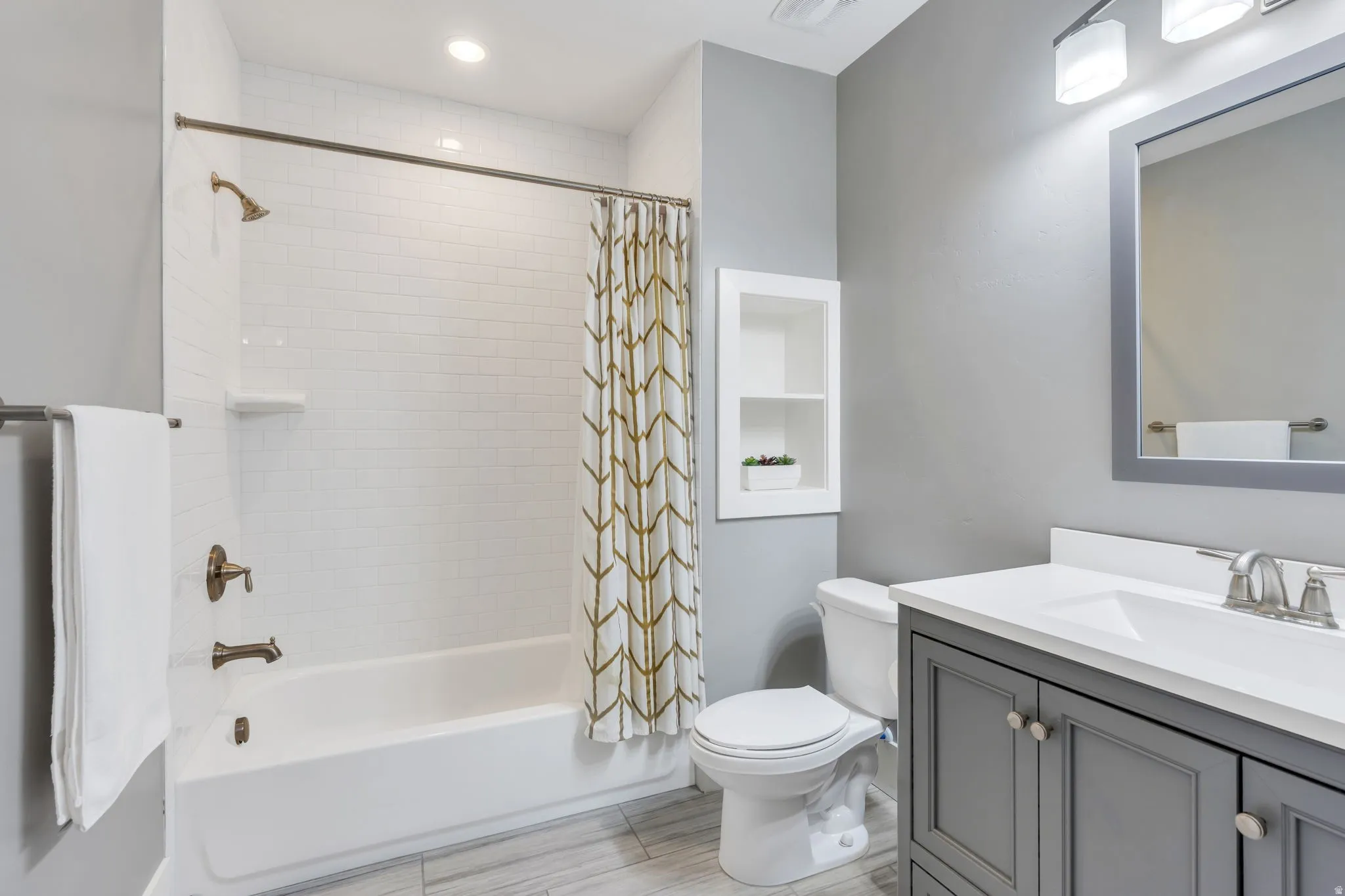 White subway tile shower surround with bronze fixtures