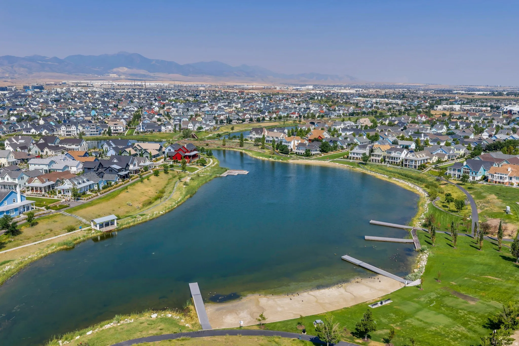 Expansive community lake with multiple docks, surrounded by residential properties and green spaces