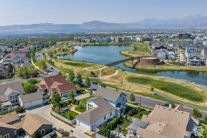 Lakeside community with extensive green spaces, pedestrian pathways, and a bridge feature