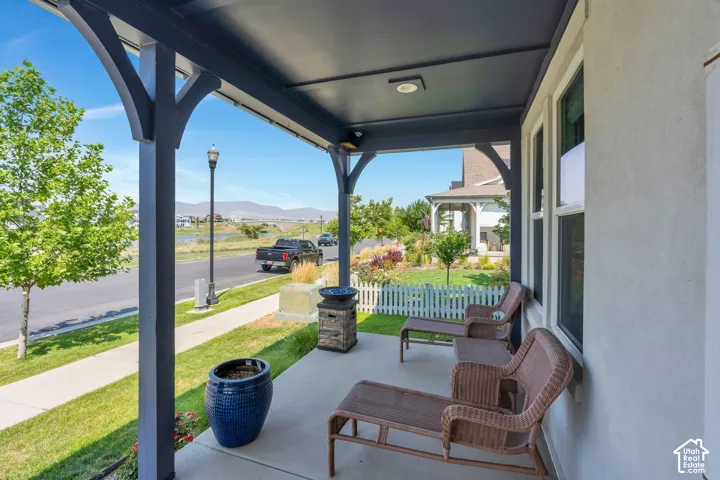 Covered porch with dark-painted structural posts and a ceiling-mounted light fixture