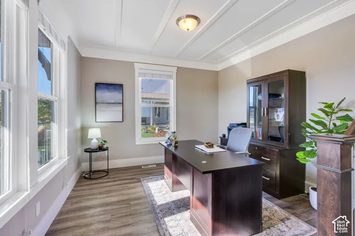 Coffered ceiling detail, wood-finish flooring, recessed lighting, multiple windows with white trim, and a built-in wood-finish cabinet