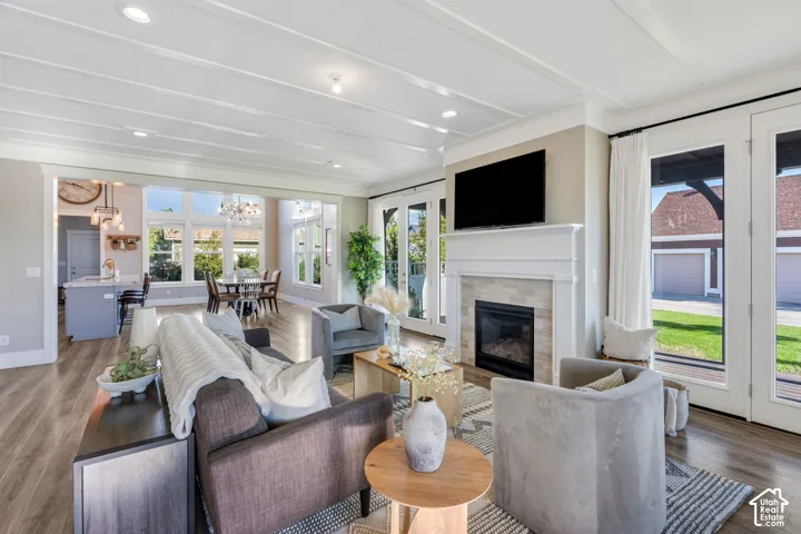 Bright open-concept living area featuring hardwood flooring, a gas fireplace with white surround and built-in cabinetry, and a wall-mounted flat-screen television