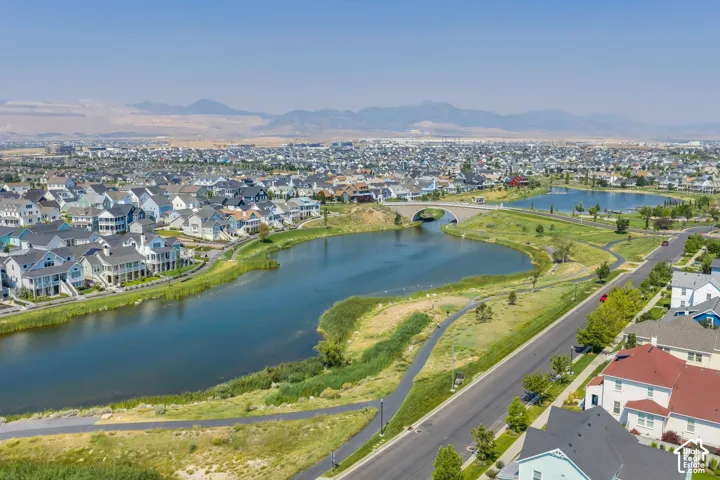Aerial perspective showcasing multiple residential structures, two bodies of water, and a paved pathway
